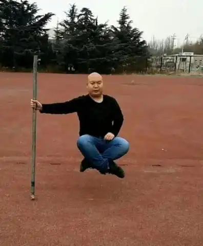 男子用一杆支撑身体表演空中打坐,不料被一名路人识破真相