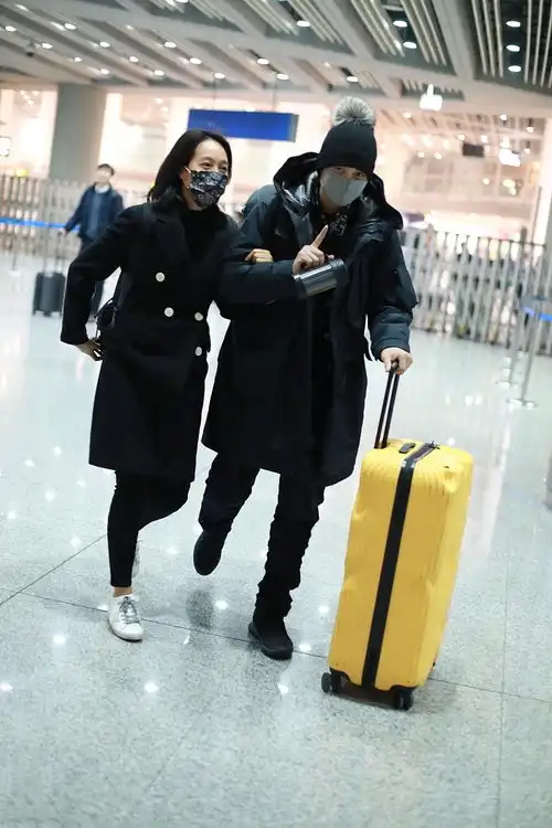 朱丹周一围低调走机场,黑色情侣装很有夫妻相,亲密挽手越发恩爱