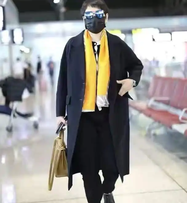 58岁张凯丽是中老年穿搭模板,黑色大衣叠搭黄色围巾,优雅减龄
