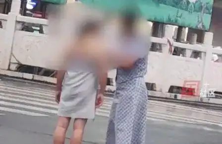 洛阳女子赤裸全身站在街头,路人围观拍照,好心人为她裹上围巾