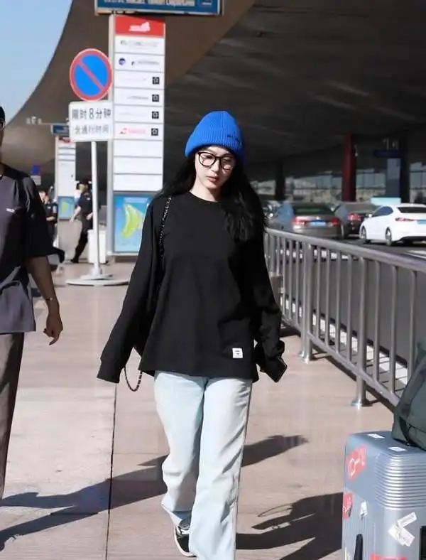 李菲儿穿得真保守,黑色卫衣配长裙还把头蒙住,一走路却秀出了腿